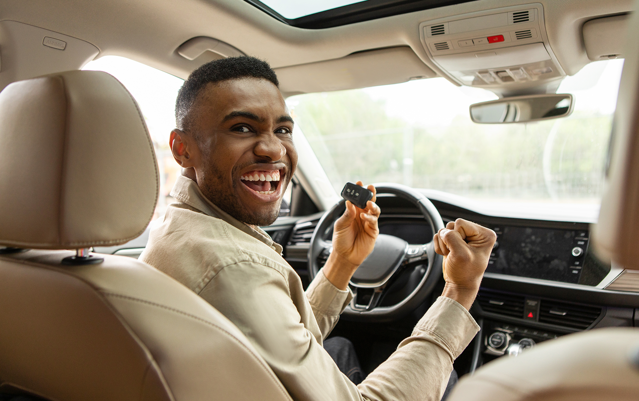 Man celebrating new car with keys inside.